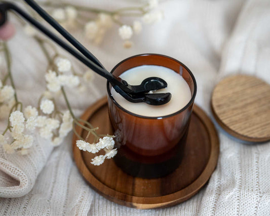 soja was geurkaars in amberglas met houten deksel en bloemen eromheen